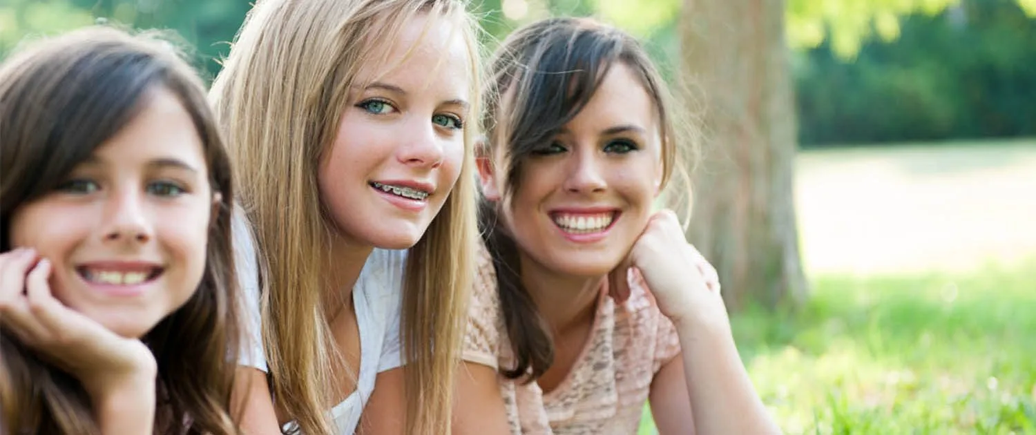 The Ultimate Braces-Friendly Diet: What to Eat and What to Avoid 2 Teenager with braces hangs out with friends in Asheville park