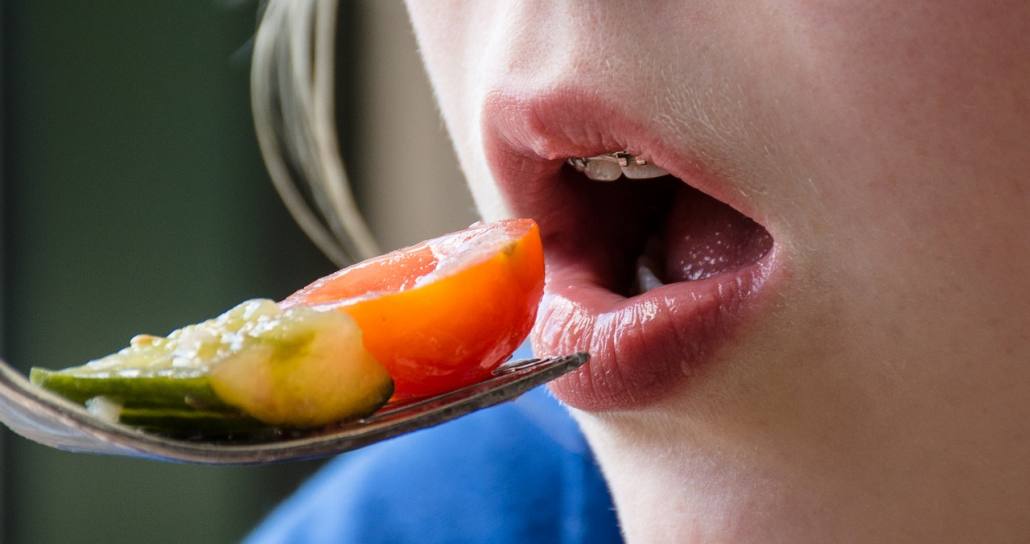 Girl with braces eats fruits