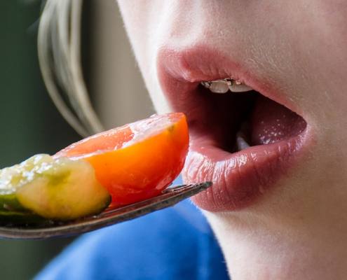 Girl with braces eats fruits