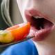 Girl with braces eats fruits