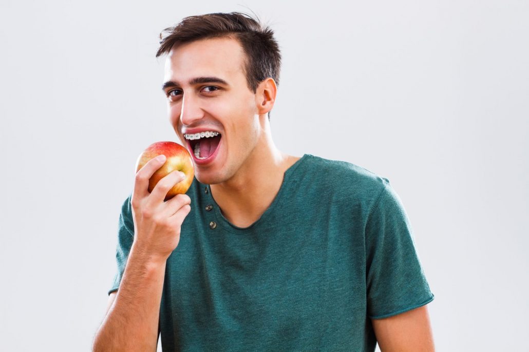 Man with braces snacking on an apple in Western North Carolina