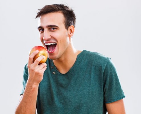Man with braces snacking on an apple in Western North Carolina