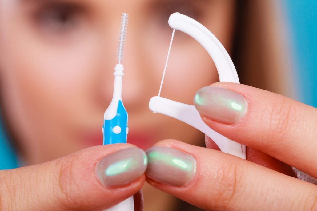 Woman learns how to floss with braces on her teeth