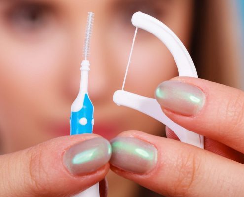 Woman learns how to floss with braces on her teeth