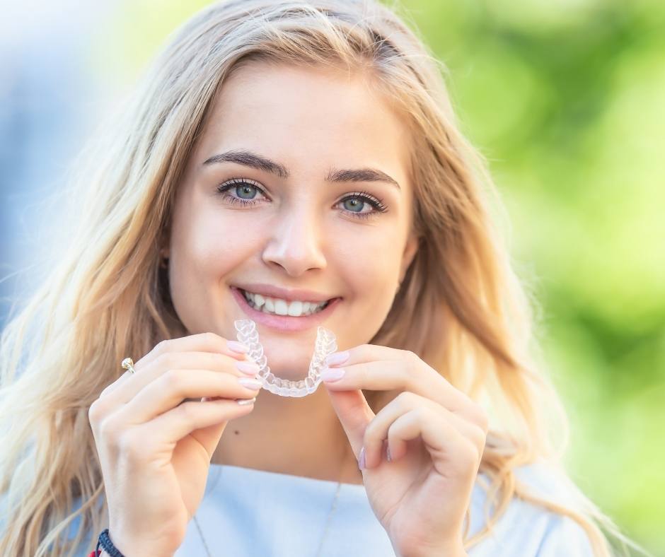 Teen holding Invisalign aligner