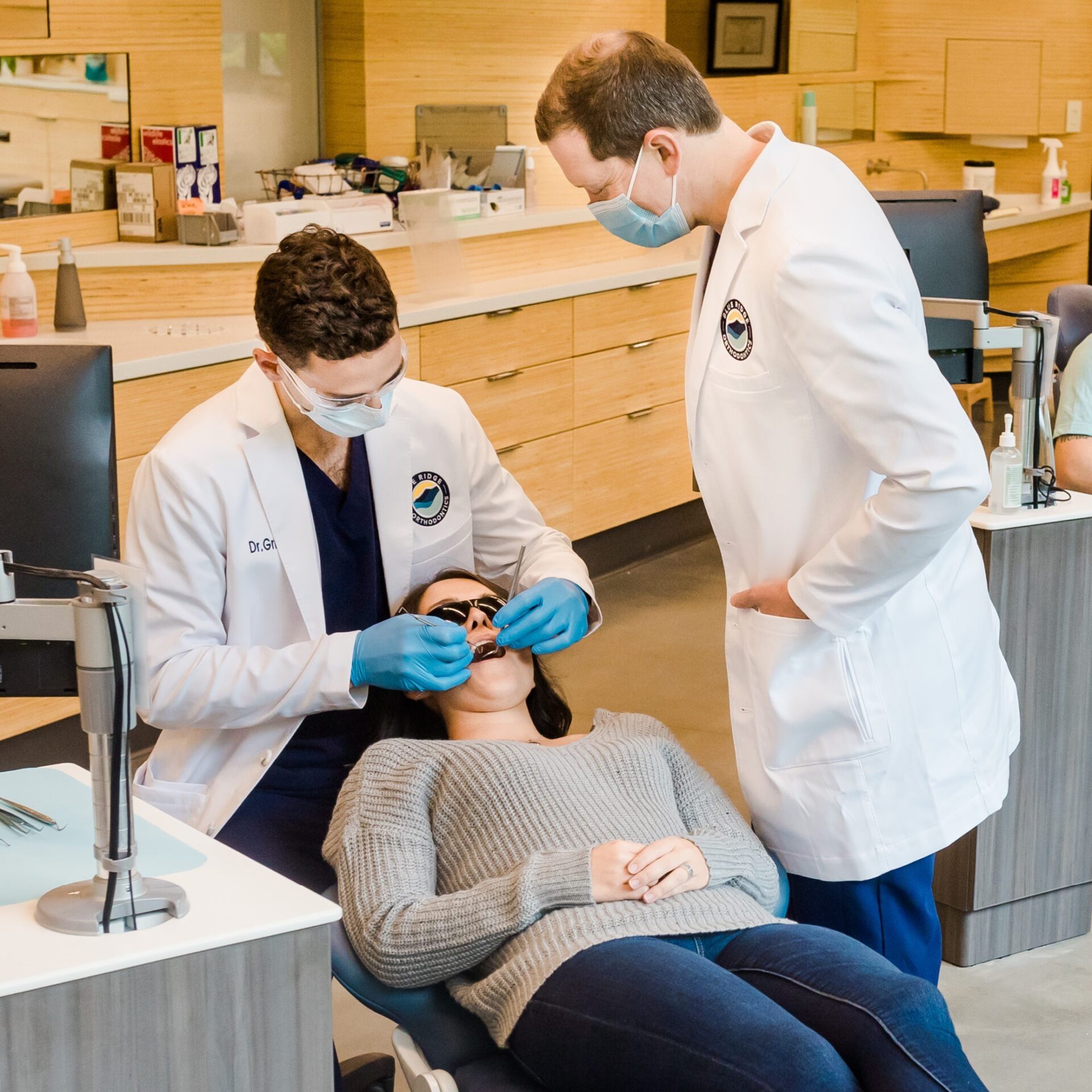 Dr. Griffeth and Dr. Roberts apply brackets to a patients teeth for braces