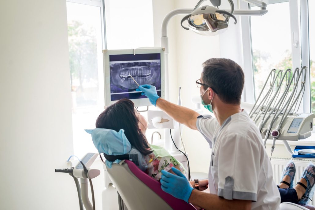 Doctor dentist showing patient's teeth on X-ray